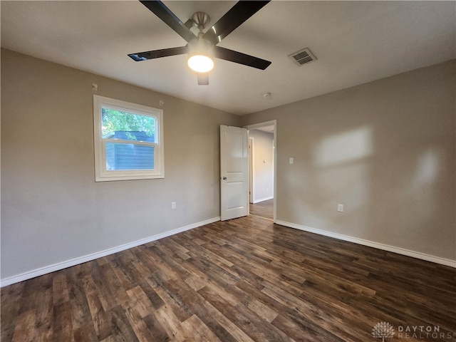 empty room with ceiling fan and dark hardwood / wood-style flooring