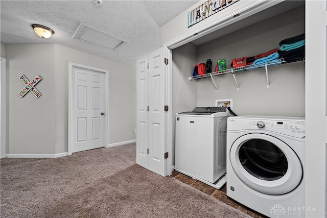 laundry room featuring a textured ceiling, dark carpet, and independent washer and dryer