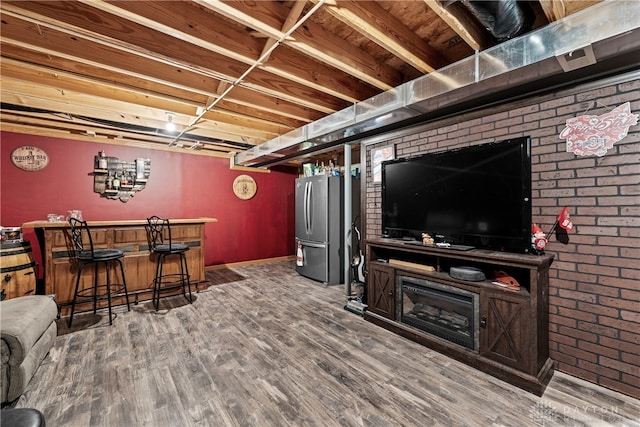 interior space with indoor bar, hardwood / wood-style floors, and stainless steel refrigerator