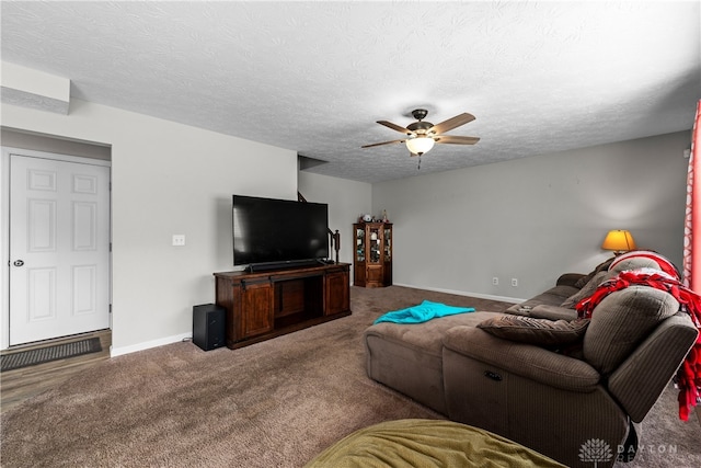 living room with ceiling fan, carpet flooring, and a textured ceiling