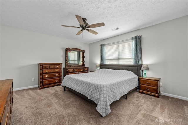 bedroom with ceiling fan, a textured ceiling, and carpet