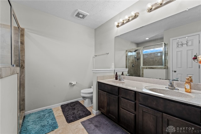 bathroom with vanity, an enclosed shower, a textured ceiling, tile patterned floors, and toilet