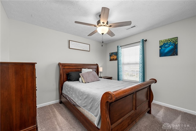 bedroom featuring ceiling fan, a textured ceiling, and carpet