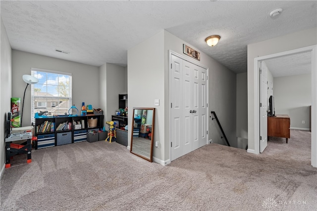 interior space featuring a textured ceiling and carpet floors