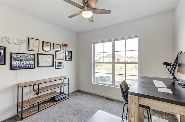 carpeted office space with ceiling fan