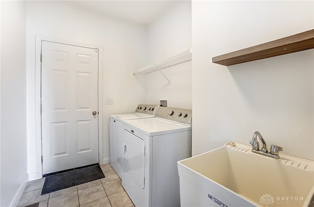 laundry area with light tile patterned flooring, sink, and washing machine and clothes dryer