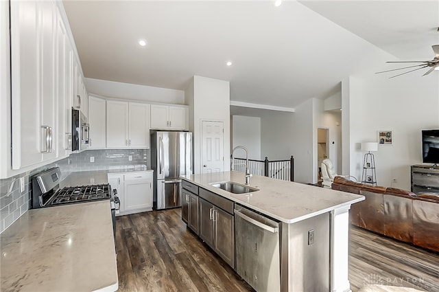 kitchen featuring an island with sink, sink, dark wood-type flooring, white cabinetry, and appliances with stainless steel finishes