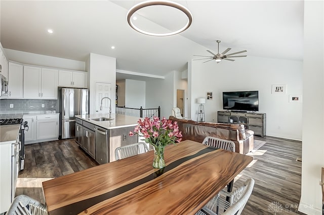 dining room featuring vaulted ceiling, dark hardwood / wood-style flooring, ceiling fan, and sink