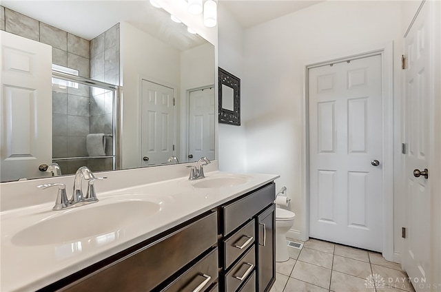 bathroom with tile patterned flooring, a shower with door, vanity, and toilet