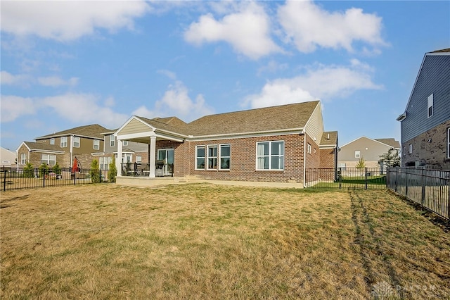 rear view of property with a yard and a patio