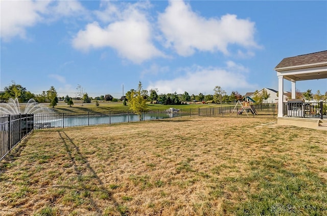 view of yard featuring a playground and a water view