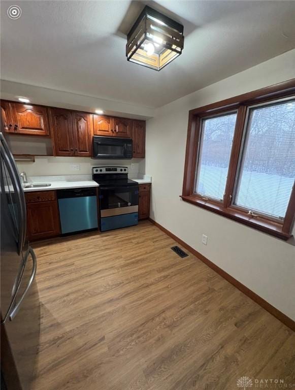 kitchen featuring sink, light hardwood / wood-style floors, and appliances with stainless steel finishes