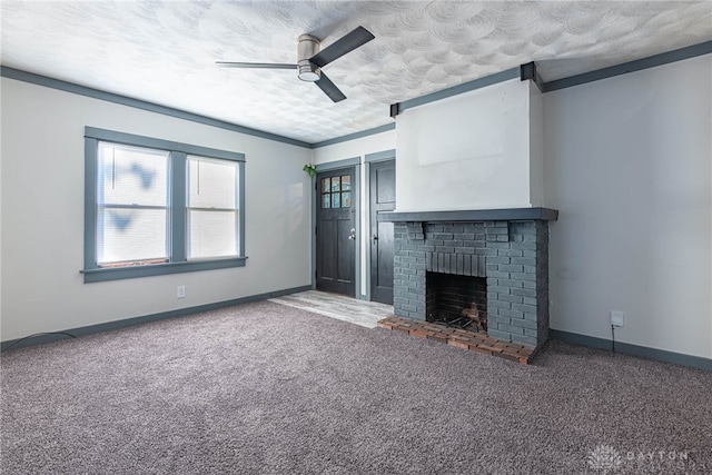 unfurnished living room with ceiling fan, ornamental molding, a brick fireplace, a textured ceiling, and carpet