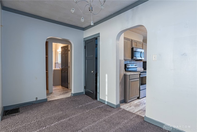 empty room featuring light carpet and a notable chandelier