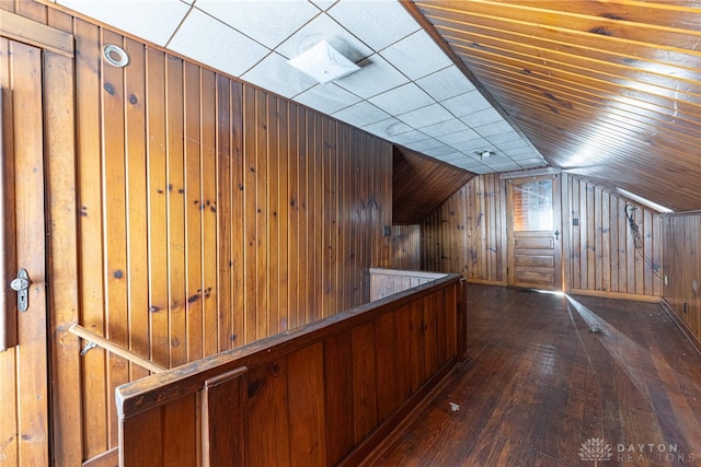 bonus room with wood walls, hardwood / wood-style floors, and vaulted ceiling