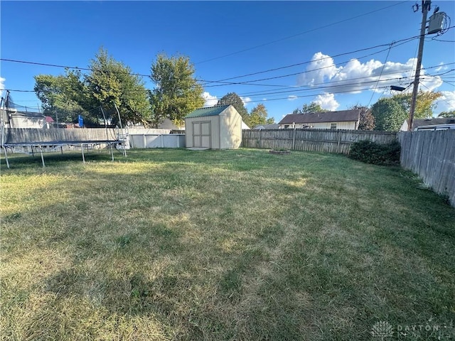 view of yard featuring a trampoline and a storage shed