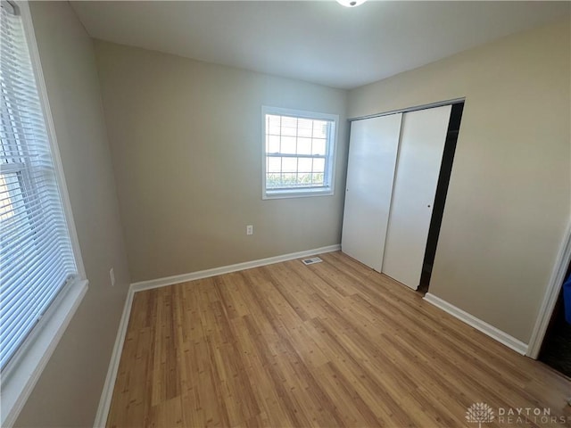 unfurnished bedroom with light hardwood / wood-style floors and a closet