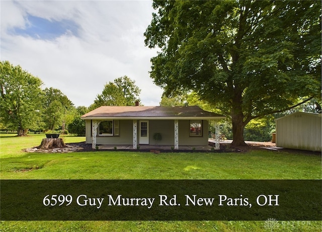 back of property featuring a storage shed, a lawn, and a porch