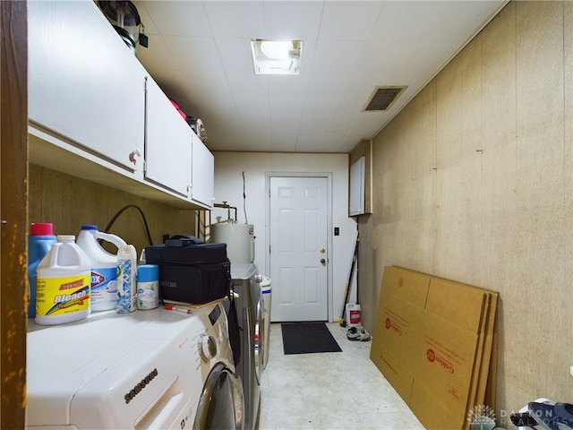 washroom with electric water heater, cabinets, and separate washer and dryer