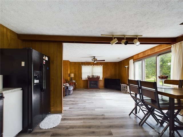 dining area with a textured ceiling, light wood-type flooring, and ceiling fan