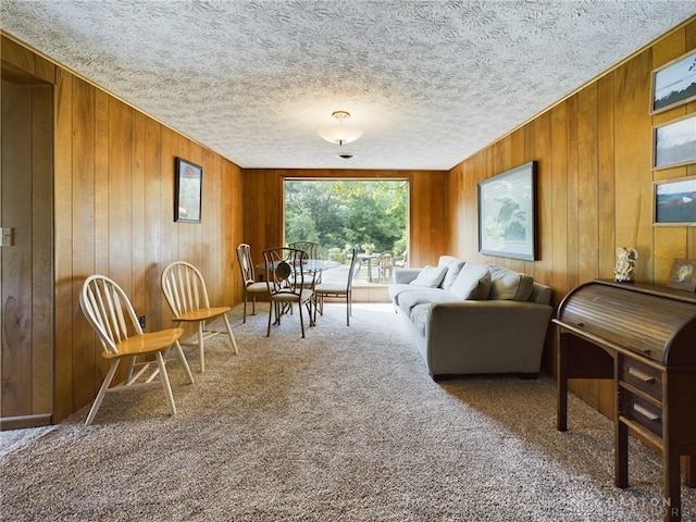 living room with a textured ceiling, wooden walls, and carpet floors