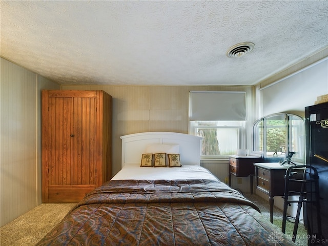 bedroom with a textured ceiling and carpet floors