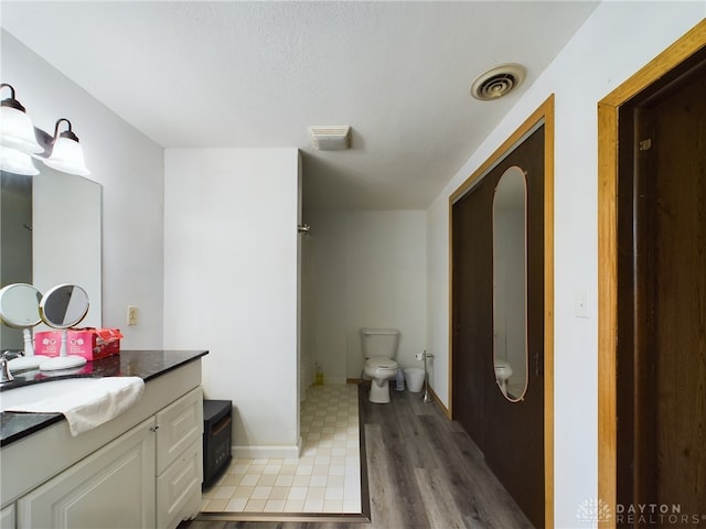 bathroom featuring vanity, toilet, and hardwood / wood-style flooring