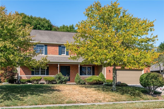 view of front facade featuring a garage, a porch, and a front lawn