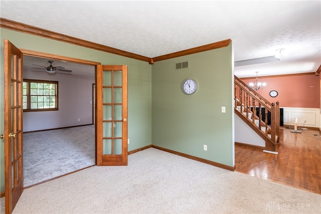 unfurnished room with a textured ceiling, carpet, and ornamental molding