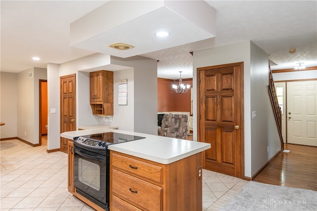 kitchen featuring a textured ceiling, black electric range, an inviting chandelier, and pendant lighting