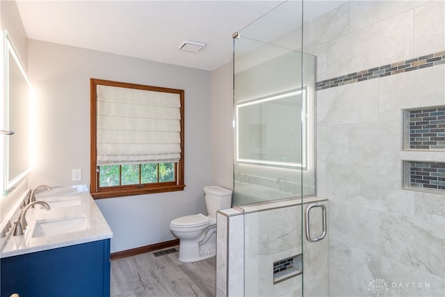 bathroom with vanity, toilet, an enclosed shower, and hardwood / wood-style flooring