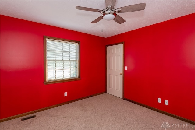 empty room with ceiling fan and light colored carpet