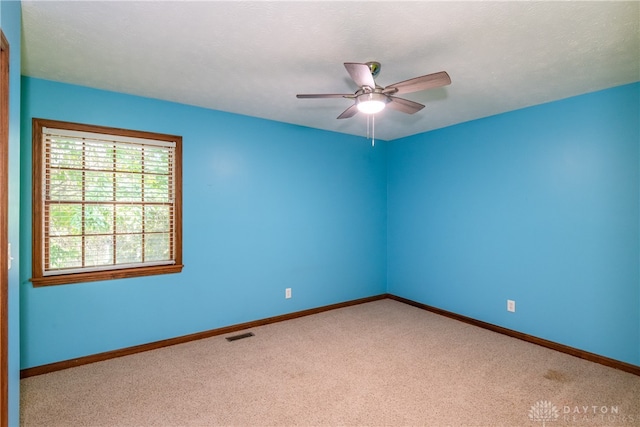 carpeted spare room featuring a textured ceiling and ceiling fan