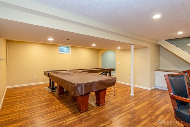 recreation room with pool table, light hardwood / wood-style floors, and a textured ceiling