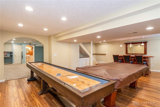 game room featuring wood-type flooring, a textured ceiling, billiards, and bar