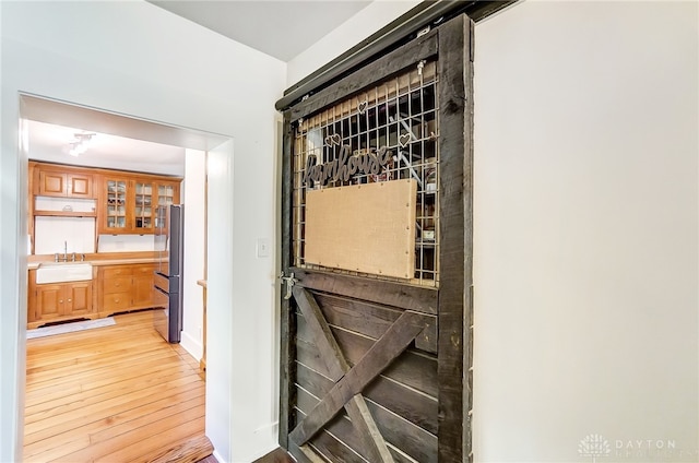 wine area with light hardwood / wood-style floors and sink