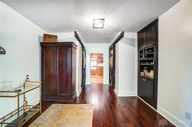 corridor featuring dark hardwood / wood-style floors and a barn door