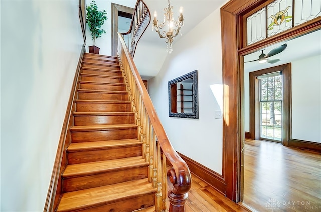 stairs featuring hardwood / wood-style floors and a notable chandelier