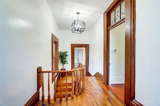 corridor featuring an inviting chandelier and hardwood / wood-style floors