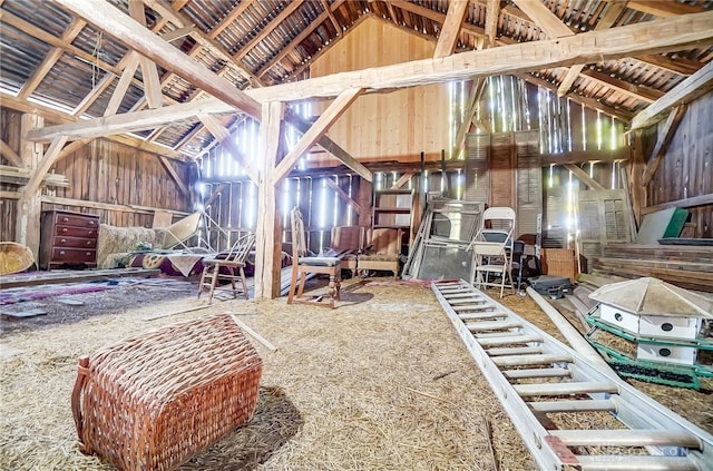 misc room with wood walls, beam ceiling, and high vaulted ceiling