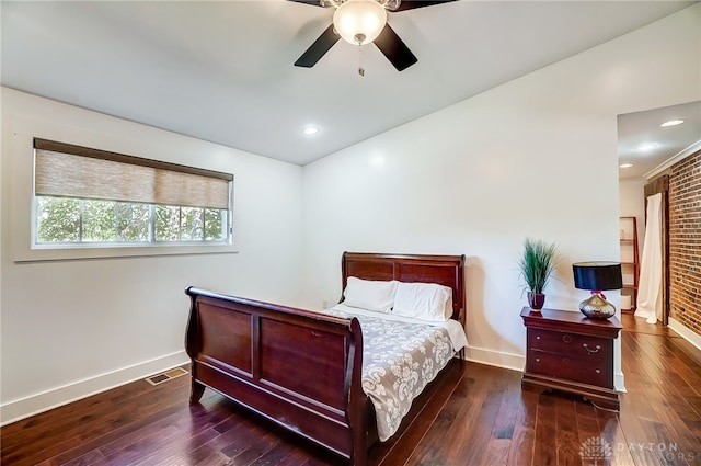 bedroom featuring ceiling fan, brick wall, and dark hardwood / wood-style flooring