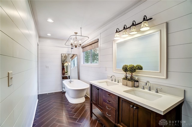 bathroom featuring vanity, parquet floors, a bath, an inviting chandelier, and crown molding