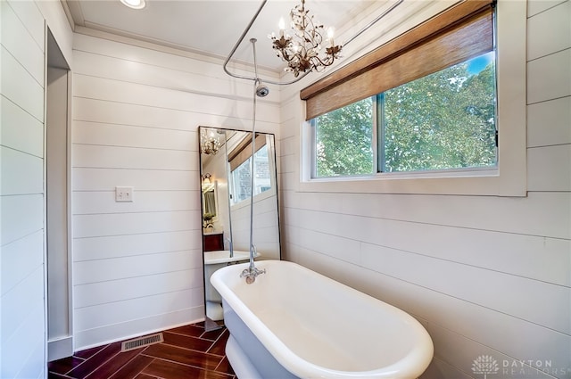 bathroom featuring a bathtub, wooden walls, and an inviting chandelier