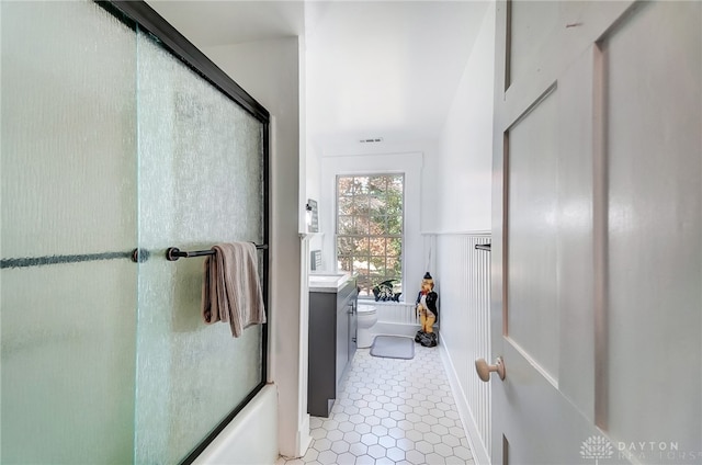 full bathroom featuring tile patterned floors, combined bath / shower with glass door, vanity, and toilet