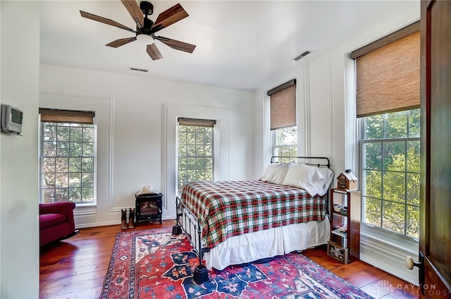 bedroom featuring multiple windows, hardwood / wood-style flooring, and ceiling fan