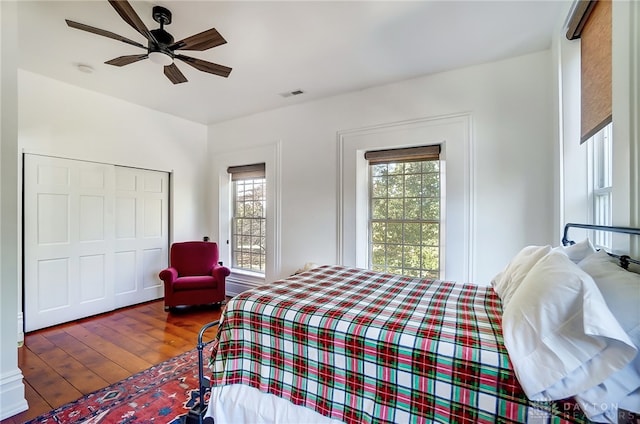 bedroom with ceiling fan, a closet, and dark wood-type flooring