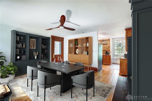 dining space with wood-type flooring and ceiling fan