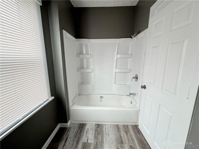 bathroom with wood-type flooring and bathtub / shower combination