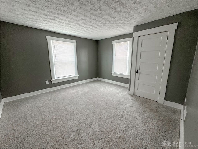 carpeted spare room with a textured ceiling