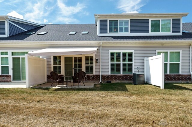 rear view of house featuring central AC, a yard, and a patio